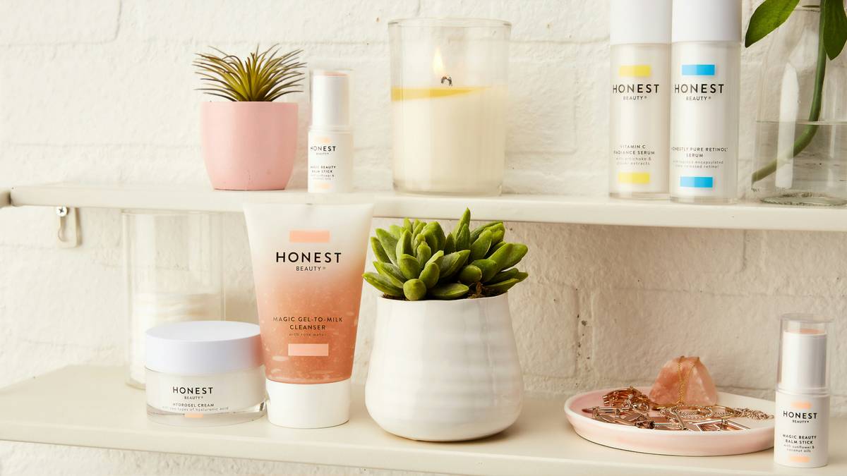 A sleek acrylic cosmetic organization shelf holding makeup brushes, lipsticks, and skincare serums arranged by category