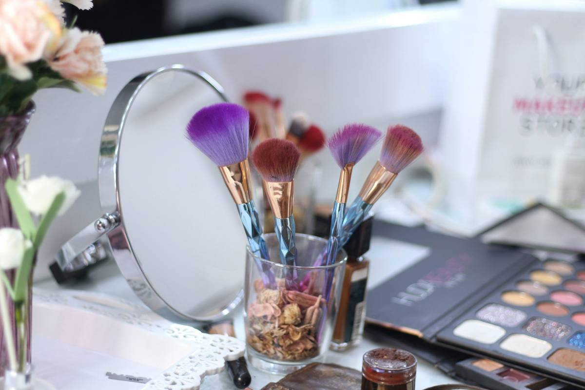 Minimalist vanity with organized beauty storage system featuring tiered makeup stands and labeled compartments